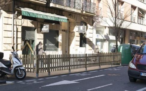 Una terraza colocada en una zona de aparcamiento.