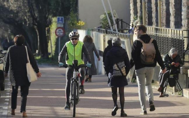Un ciclista y peatones comparten espacio en el paseo de Txaparrene, en Intxaurrondo.