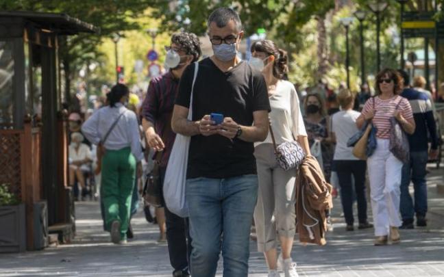 Gente paseando con la mascarilla durante la pandemia en epoca en la que la mascarilla no es obligacion en exteriores