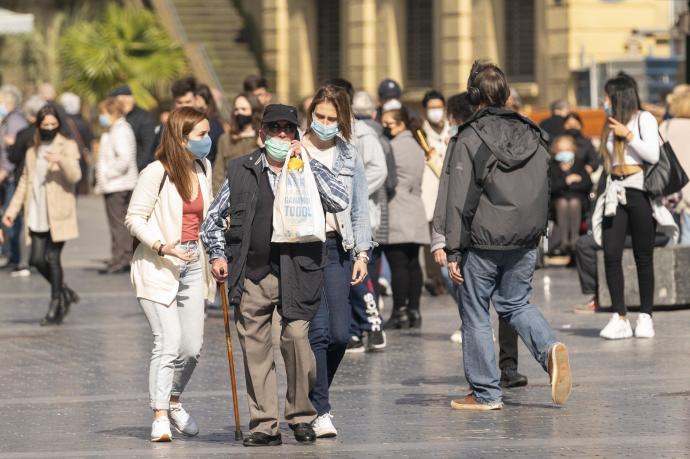 Gente paseando protegidas con mascarillas por la pandemia del Coronavirus
