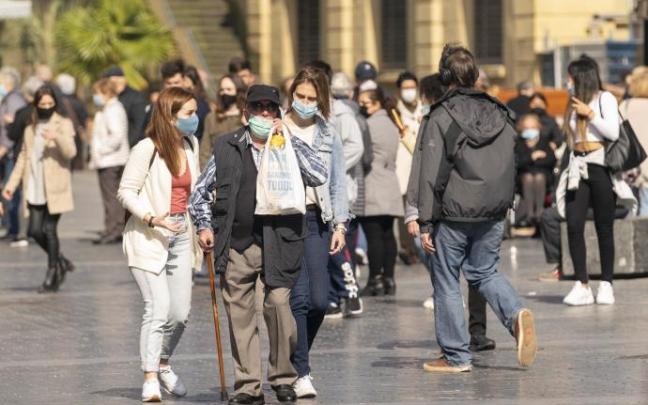 Gente paseando protegidas con mascarillas por la pandemia del Coronavirus