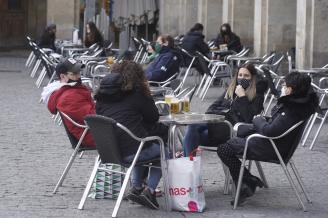 Personas sentadas en la terraza de un bar con mascarilla para evitar contagios de coronavirus.