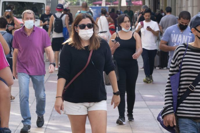 Personas andando por la calle con mascarilla para evitar contagios de coronavirus.