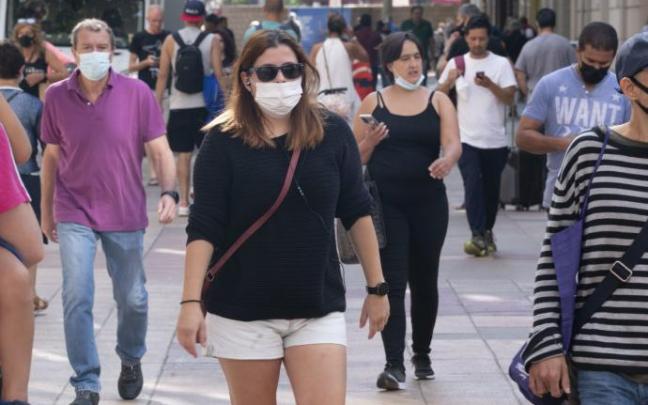Personas andando por la calle con mascarilla para evitar contagios de coronavirus.