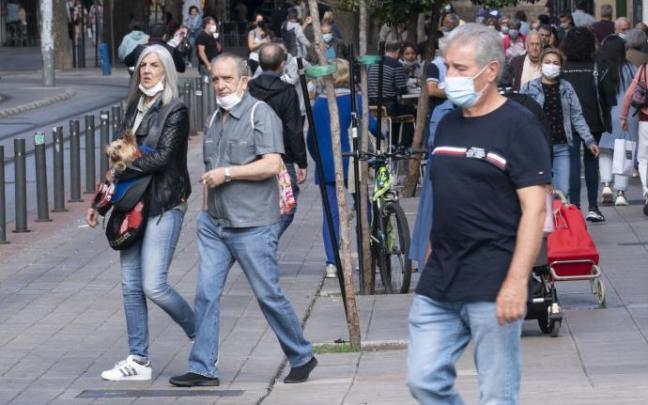 Personas andando por la calle con mascarilla para evitar contagios de coronavirus covid 19.