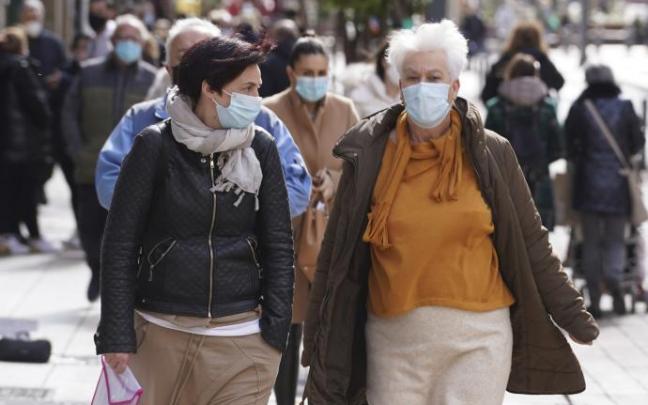 Varias personas andando por la calle con mascarilla para evitar contagios de coronavirus.