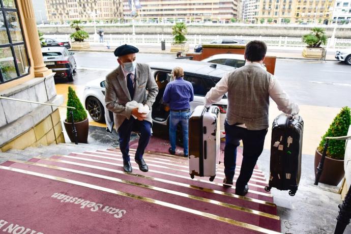 Un trabajador baja maletas en el hotel María Cristina.