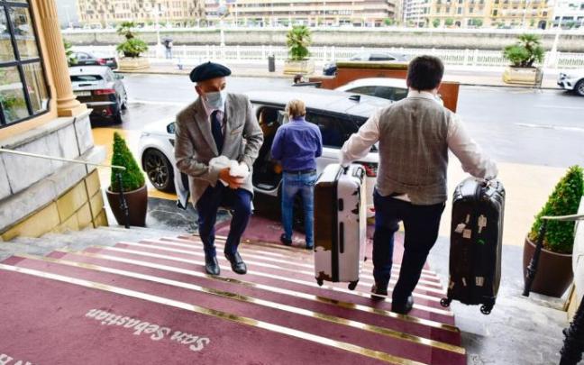 Un trabajador baja maletas en el hotel María Cristina.