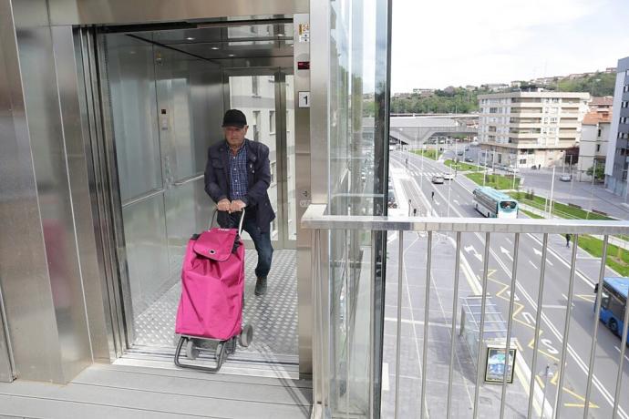 Un hombre sale del nuevo ascensor con el carro de la compra.