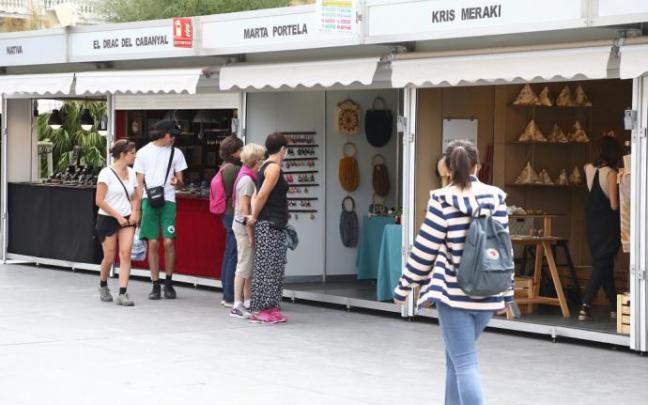 Varias personas pasean junto a los puestos de artesanía en Donostia
