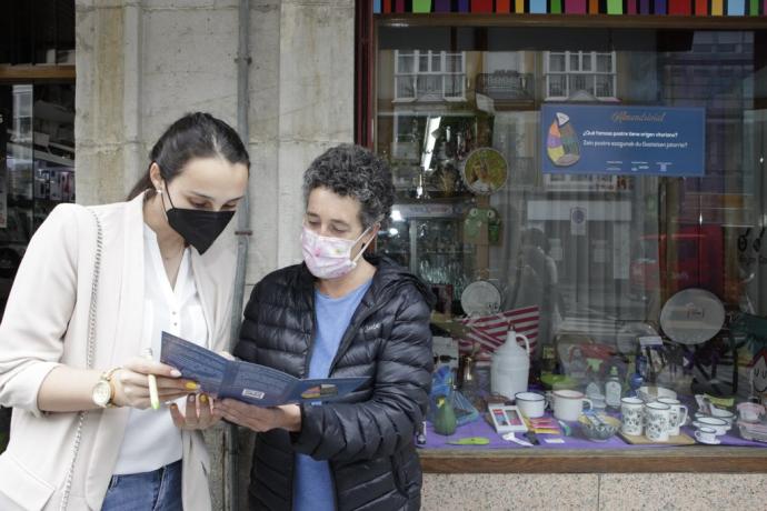 Una alavesa sellando su cartilla en el escaparate de uno de los establecimientos participantes.