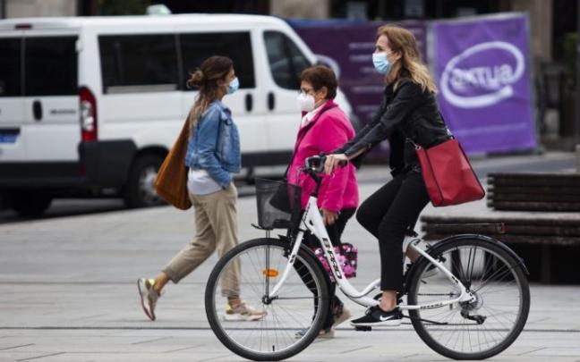 Una ciclista circula con mascarilla por el centro de Vitoria.
