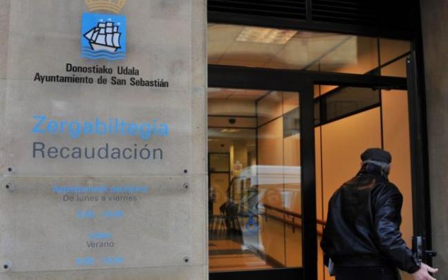 Un hombre entra en una oficina de recaudación municipal. Un hombre entra en una oficina de recaudación municipal.