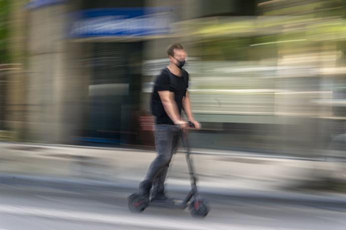 Un hombre circula en patinete por Donostia.