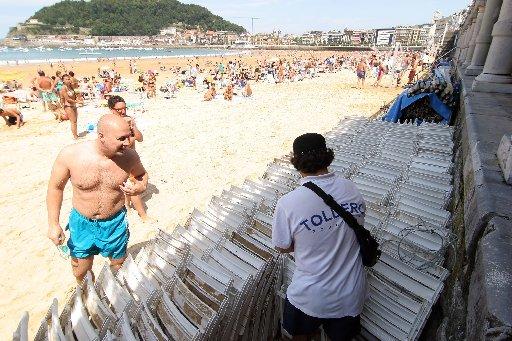 Un toldero organiza las sillas almacenadas en La Concha.