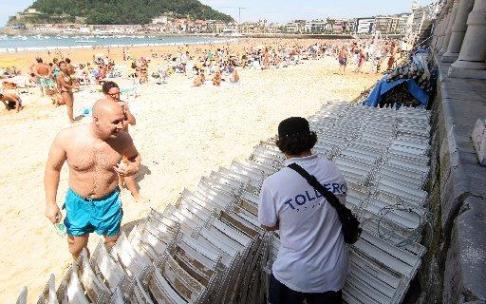 Un toldero organiza las sillas almacenadas en La Concha.