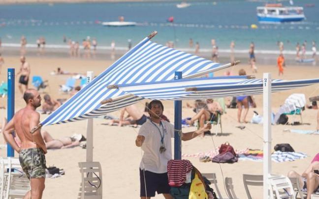 Un trabajador coloca uno de los toldos en La Concha.