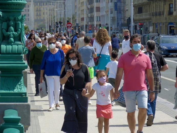 Gente transita por el puente de la Zurriola en Donostia.