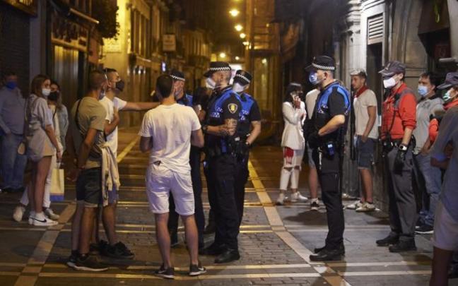 Agentes de Policía Municipal y Foral conversan con unos jóvenes. Agentes de Policía Municipal y Foral conversan con unos jóvenes.