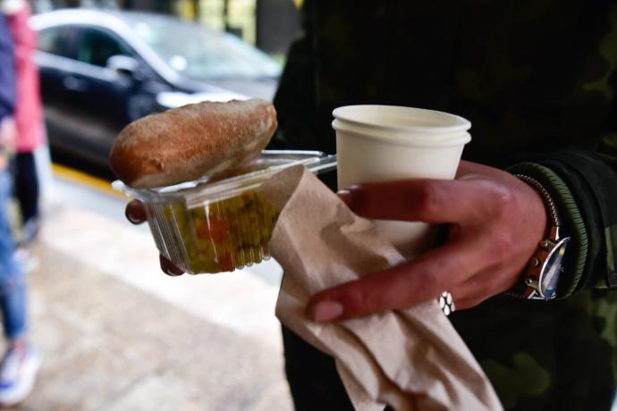 Una persona recoge una ración de cena en Donostia.