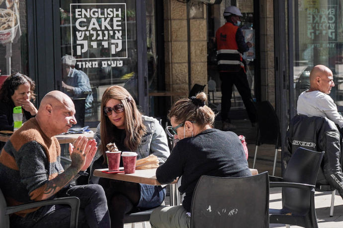 Ciudadanos israelíes en un café sin mascarilla.