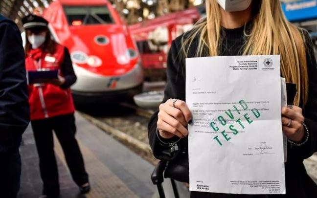 Una mujer muestra su pasaporte sanitario en una estación de tren en Roma Una mujer muestra su pasaporte sanitario en una estación de tren en Roma