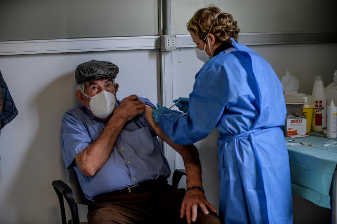 Una persona mayor recibe la vacuna contra el covid en Milán.