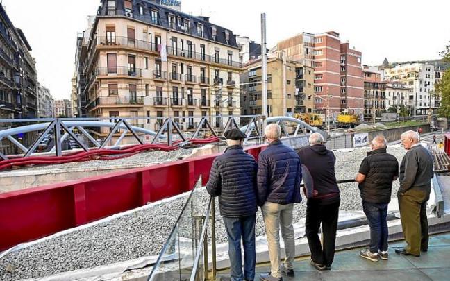 Varios vecinos observan el desarrollo de las obras en Iztueta, ayer por la tarde.