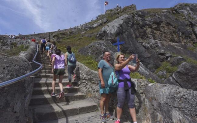 Dos caminantes se hacen una selfie en Gaztelugatxe Dos caminantes se hacen una selfie en Gaztelugatxe