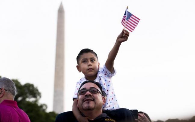 Un hombre sigue junto a su hijo el discurso de Biden en el Día de la Independencia Un hombre sigue junto a su hijo el discurso de Biden en el Día de la Independencia