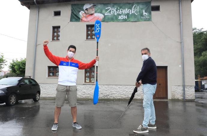 Andreas Orive, presidente de Barrika Piragua Taldea, club al que perteneció Jon, y el alcalde, Roberto Muñoz, junto a la pancarta de apoyo al golfista.
