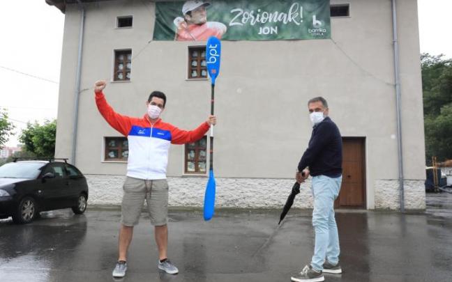 Andreas Orive, presidente de Barrika Piragua Taldea, club al que perteneció Jon, y el alcalde, Roberto Muñoz, junto a la pancarta de apoyo al golfista.