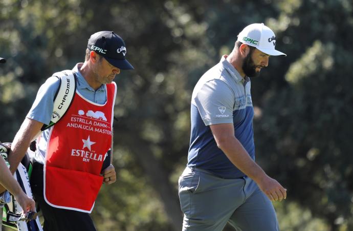 Jon Rahm y su caddie Adam Hayes caminan cabizbajos por el campo de Valderrama ayer jueves.