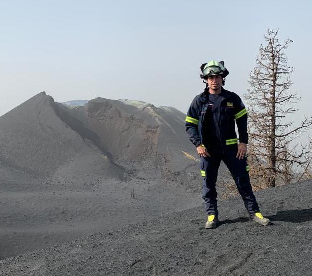 El oficial de Bomberos de Bilbao, Jon Sánchez, con el cráter del Cumbre Vieja de La Palma al fondo