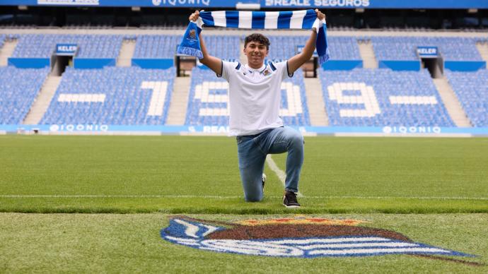 Jonathan Gómez sujeta una bufanda de la Real Sociedad en Anoeta.