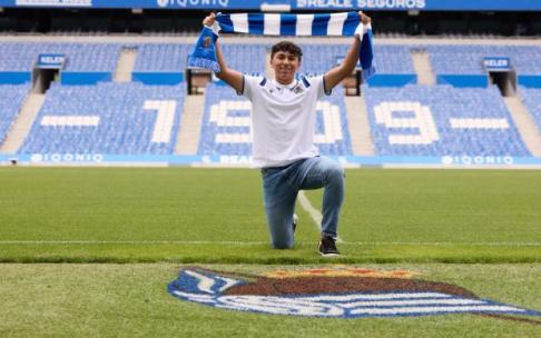 Jonathan Gómez sujeta una bufanda de la Real Sociedad en Anoeta.