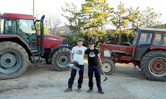 Los hermanos Aaron y Saúl Lerga, de Orísoain, posan con los tractores y herramientas que utilizan para trabajar.