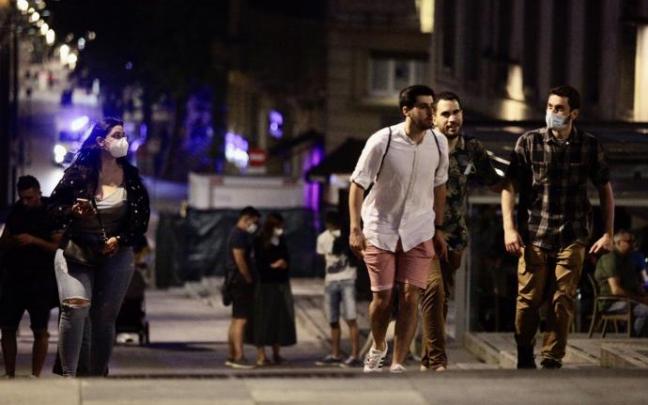Varios jóvenes pasean por el centro de Vitoria en la noche de ayer.