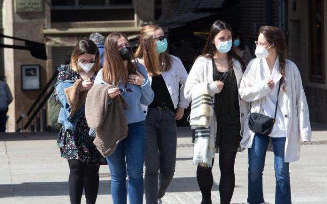 Un grupo de jóvenes pasean por una calle.