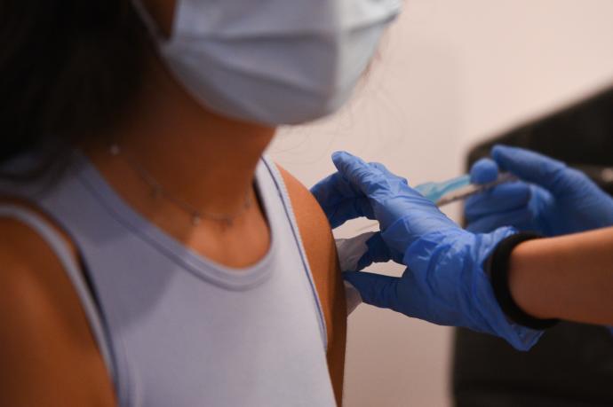 Una joven recibe una vacuna anticovid.