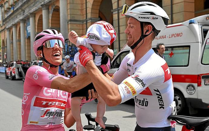 Juanpe López bromea con el bebé de su compañero Edward Theuns, antes de una etapa del presente Giro. Foto: Efe