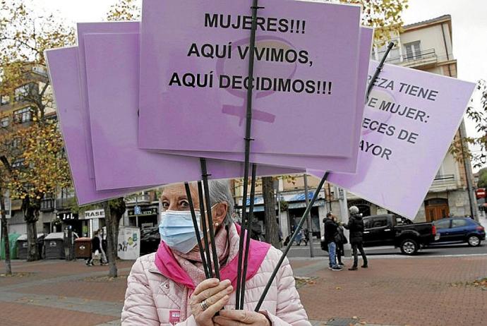 Una manifestante porta varios carteles reivindicativos. Foto: Pilar Barco