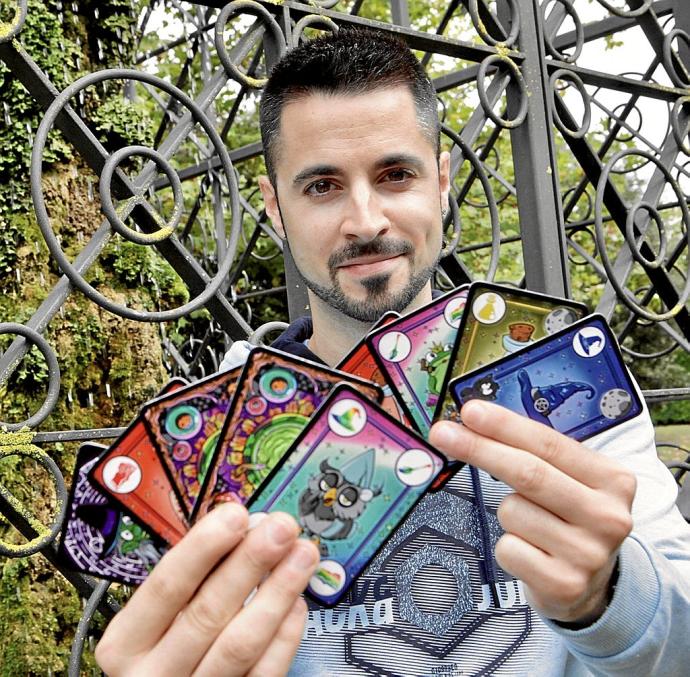 El vitoriano Iván Losada posando con su juego de cartas 'Ordered Witch. Un juego de brujas ordenadas', para el que ha lanzado una campaña de recogida de fondos, a través de una plataforma de internet llamada Verkami. En pequeño, algunas de sus cartas y 'm