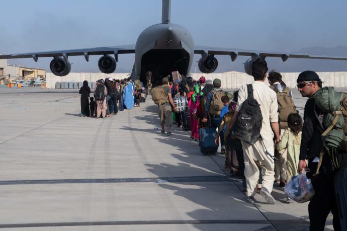 Afganos hacen cola para embarcar en un avión en Kabul.