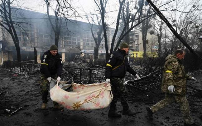 Policías ucranianos trasladan un cadáver.