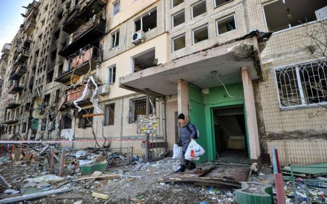 Una mujer abandona uno de los edificios de viviendas bombardeados en Kiev Una mujer abandona uno de los edificios de viviendas bombardeados en Kiev