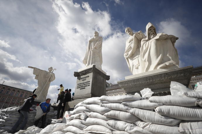 Varios voluntarios cubren con sacos de arena los monumentos en Kiev.
