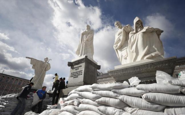 Varios voluntarios cubren con sacos de arena los monumentos en Kiev.