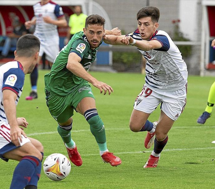 Kike Barja, autor del tanto de Osasuna en el día de ayer, trata de marcharse de un jugador del Mirandés.