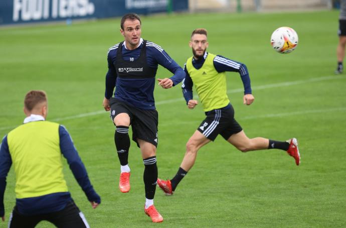 Kike García toca balón en presencia de Roberto Torres.